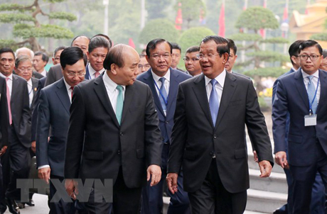 Thủ tướng Nguyễn Xuân Phúc trao đổi thân mật với Thủ tướng Campuchia Samdech Techo Hun Sen trên đường đến Trụ sở Chính phủ để hội đàm.