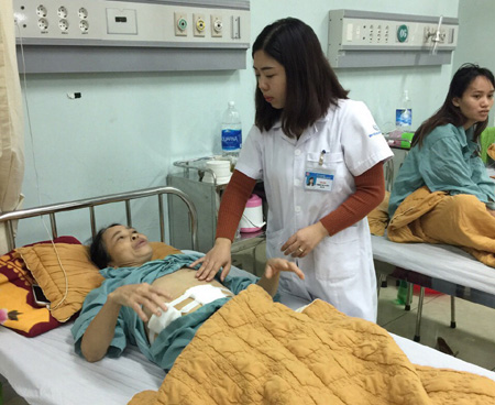 Bác sỹ Tòng Thị Biên kiểm tra vết mổ của bệnh nhân hậu phẫu.