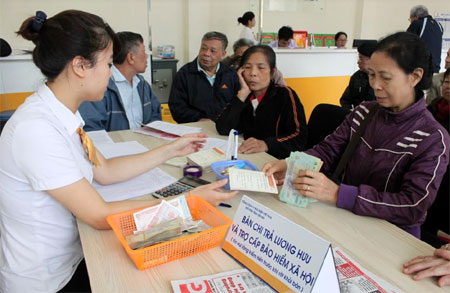 Người dân đến lĩnh lương hưu và trợ cấp BHXH tại điểm chi trả Bưu điện huyện Yên Bình.
