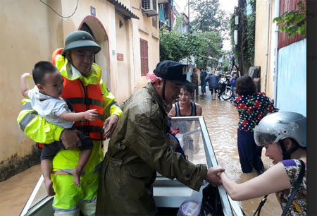 Lực lượng công an giúp người dân thành phố Yên Bái di chuyển đến nơi an toàn trong những ngày mưa lũ.