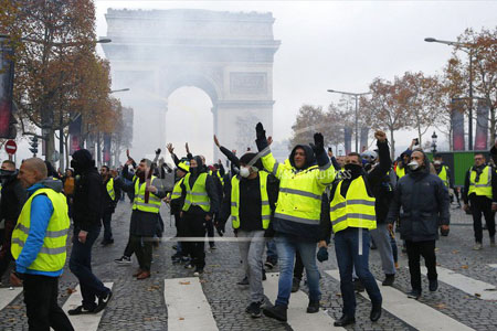 Người biểu tình mặc áo vàng chống lại việc tăng thuế nhiên liệu trên đại lộ Champs-Elysees gần Khải Hoàn Môn.
