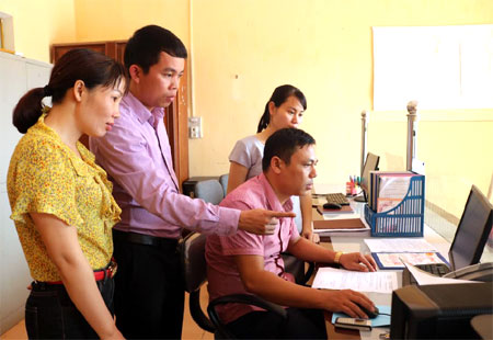 Đồng chí Trần Long Giang - Phó Chủ tịch UBND xã Hoàng Thắng (thứ 2 trái sang) trao đổi công việc với cán bộ Văn phòng UBND xã.