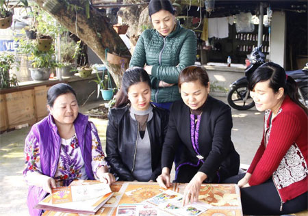 Thành viên Câu lạc bộ Khám và tư vấn sức khỏe tiền hôn nhân thị trấn Nông trường Trần Phú, huyện Văn Chấn tư vấn cho người dân địa phương.
