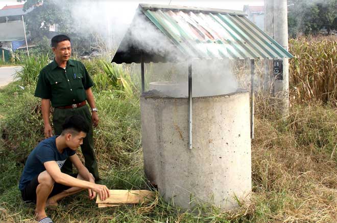 Chủ tịch Hội Cựu chiến binh Khương Văn Thịnh hướng dẫn người dân thôn Cầu Quạnh cách đốt rác trong bể.