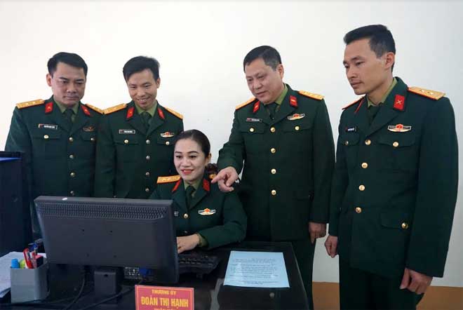 Thượng tá Trần Xuân Hướng - Trưởng ban Khoa học Quân sự Bộ CHQS tỉnh trao đổi nghiệp vụ công tác quản trị mạng với Thượng úy Đoàn Thị Hạnh và cán bộ chiến sĩ trong đơn vị.