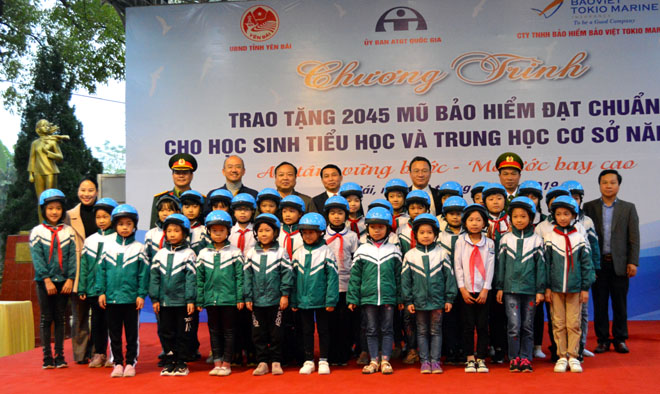 Đại diện Công ty TNHH Bảo hiểm Bảo Việt TOKIO MARINE; Uỷ ban ATGT quốc gia, lãnh đạo Ban ATGT tỉnh chụp ảnh lưu niệm với các em học sinh huyện Văn Yên.