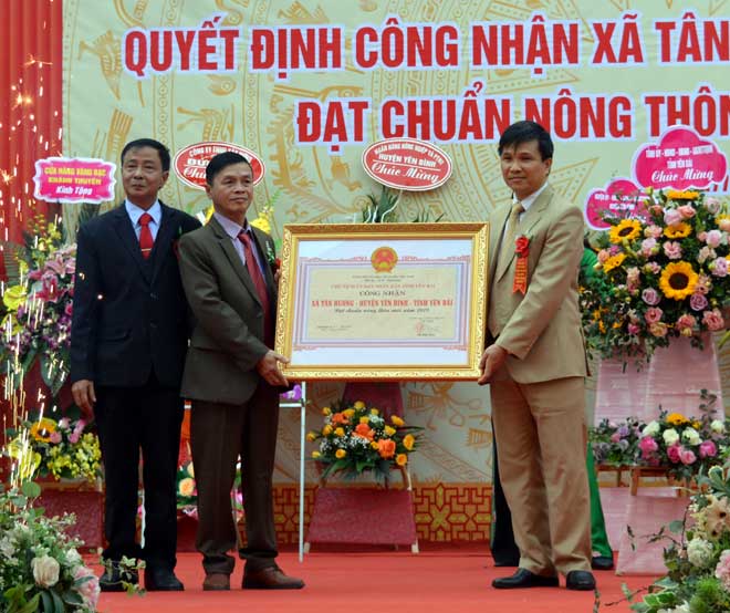 Thừa quyền của Chủ tịch UBND tỉnh Yên Bái, Phó Giám đốc Sở Nông nghiệp và Phát triển nông thôn Nguyễn Đức Điển trao Quyết định công nhận đạt chuẩn NTM cho lãnh đạo xã Tân Hương.