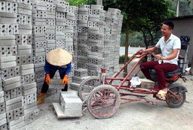 Anh La Đình Yên sử dụng chiếc xe vận chuyển gạch do anh tự chế tạo.