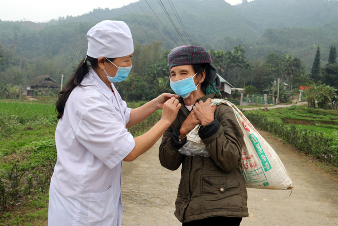 Cán bộ y tế cơ sở xã Việt Hồng, huyện Trấn Yên tuyên truyền cho người dân đeo khẩu trang khi đến nơi tập trung đông người.