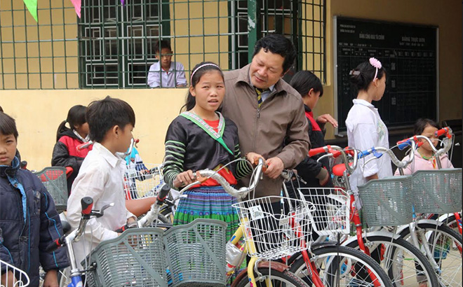 Đồng chí Vương Văn Bằng - Giám đốc Sở Giáo dục và Đào tạo, Phó Chủ tịch Hội Khuyến học tỉnh trao xe đạp cho học sinh Trường TH&THCS xã Suối Bu, huyện Văn Chấn giúp các em đến trường thuận lợi hơn.