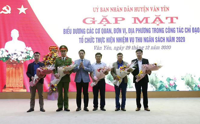 Đồng chí Luyện Hữu Chung - Bí thư Huyện ủy Văn Yên tặng hoa chúc mừng các cơ quan, đơn vị có thành tích xuất sắc trong công tác thu ngân sách  địa phương năm 2020.