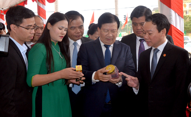 Deputy Prime Minister Trinh Dinh Dung and leaders of ministries, sectors and Yen Bai visit booths introducing OCOP products of provinces.