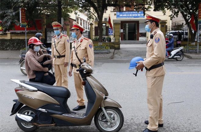 Lực lượng Cảnh sát giao thông huyện Văn Yên nhắc nhở và trao mũ bảo hiểm đạt chuẩn cho người tham gia giao thông.