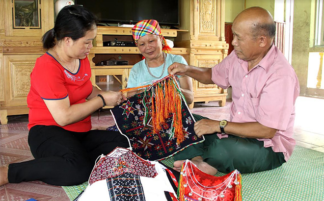 Ông Đặng Hồng Quân - Trưởng Giám dòng họ Đặng (bên phải), tuyên truyền giáo dục về truyền thống dòng họ, lưu giữ và bảo tồn bản sắc văn hóa của người Dao.