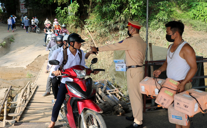 Lực lượng cảnh sát giao thông - trật tự, Công an huyện Trấn Yên phát khẩu trang miễn phí cho người dân khi đi đò ngang qua sông từ thị trấn Cổ Phúc sang xã Y Can.