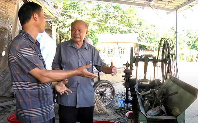 Ông Vũ Hữu Lê trao đổi với ông Trần Hồng Quân ở thôn Khe Dứa, xã Viễn Sơn, huyện Văn Yên về cách sử dụng máy băm cành quế.