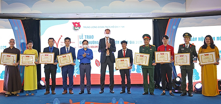 First Secretary of the Central Committee of the Ho Chi Minh Communist Youth Union Nguyen Tuan Anh and Deputy Resident Representative of the UN Development Programme (UNDP) in Vietnam Patrick Haverman (5th and 6th from left) present the National Volunteer Award 2021 to outstanding collectives and individuals.