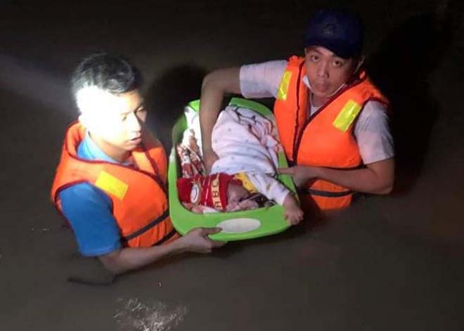 Lực lượng cứu hộ đưa em bé sơ sinh chưa đầy 1 tháng tuổi vượt dòng lũ dữ trong đêm đến nơi an toàn.