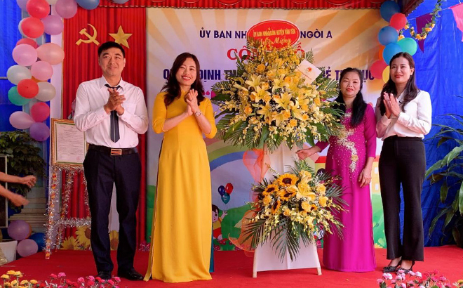 Đồng chí Lã Thị Liền - Phó Chủ tịch UBND huyện tặng hoa chúc mừng nhóm trẻ Mặt Trời Hồng, xã Ngòi A.