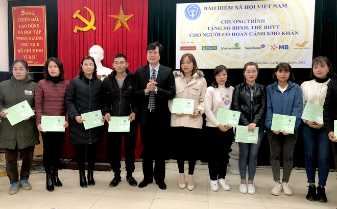 Đồng chí Vũ Quốc Tuấn - Phó Bí thư Đảng ủy BHXH Việt Nam trao sổ BHXH cho người dân có hoàn cảnh khó khăn.