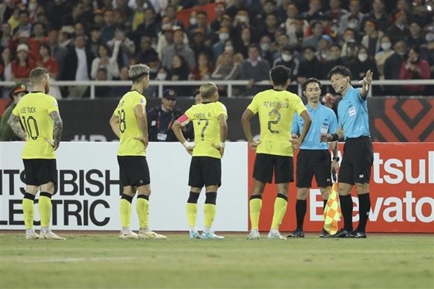 Các cầu thủ Malaysia phản ứng sau tình huống trọng tài cho đội tuyển Việt Nam hưởng quả phạt 11m ở phút 64, trong trận đấu vòng bảng AFF Cup 2022 trên sân vận động Mỹ Đình tối 27/12.