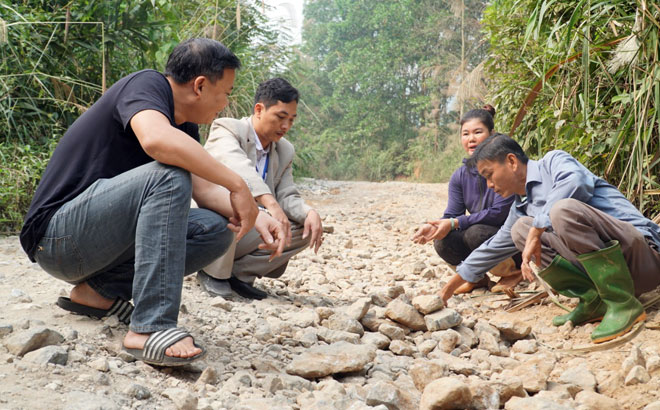 Cán bộ xã, thôn và người dân thôn Tân Tiến, xã Cảm Ân kiểm tra đoạn đường bị hư hỏng nặng.