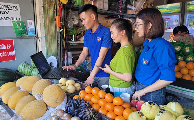 Đoàn viên thanh niên hướng dẫn các hộ kinh doanh tại chợ Đồng Tâm, thành phố Yên Bái sử dụng các sản phẩm dịch vụ công trực tuyến, các nền tảng thanh toán tiện lợi.