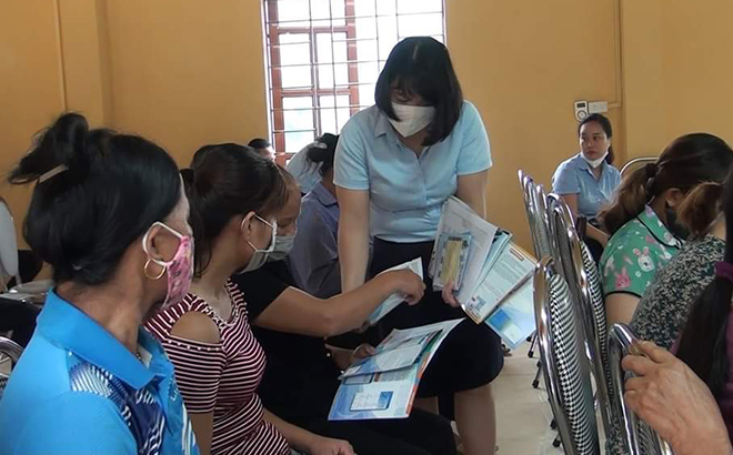 Cán bộ Bảo hiểm xã hội huyện Văn Yên tư vấn, giới thiệu và triển khai chính sách cho người dân.