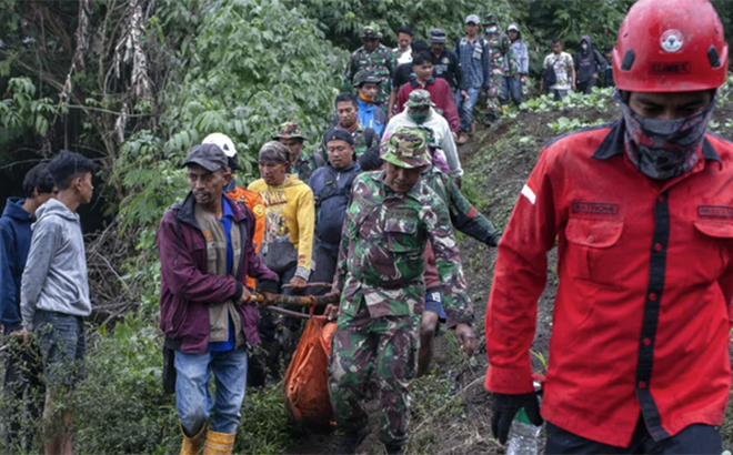 Lực lượng cứu hộ khiêng những thi thể được tìm thấy xuống núi.