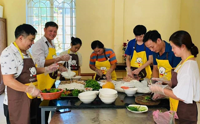 Các học viên thực hành chế biến nấu ăn tại lớp học nghề chế biến món ăn tại thị trấn Mậu A, huyện Văn Yên.