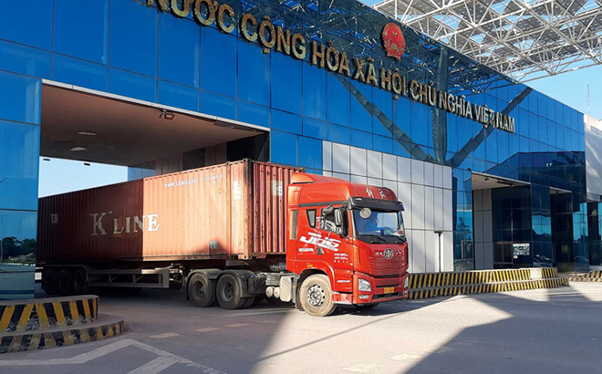 Phương tiện chở hàng hóa thông quan qua cửa khẩu Móng Cái (Việt Nam) - Đông Hưng (Trung Quốc) tại khu vực cầu Bắc Luân II.