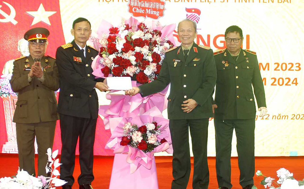 Trung tướng Hoàng Khánh Hưng - Chủ tịch Hội HTGĐLS Việt Nam tặng hoa và quà cho Hội HTGĐLS tỉnh Yên Bái.
