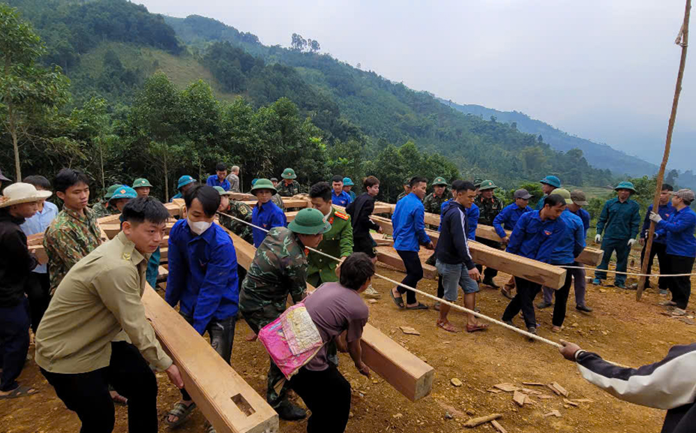 Chiến sĩ lực lượng vũ trang huyện Văn Chấn tham gia “Ngày cuối tuần cùng dân” giúp người dân Đông Nuốc, xã An Lương dựng nhà tại khu tái định cư.