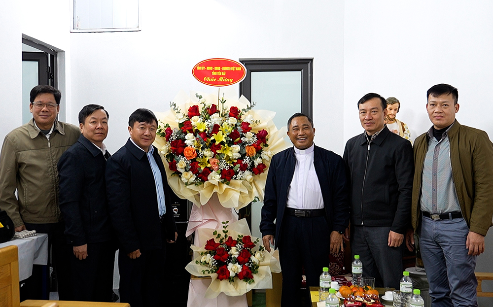 Đồng chí Giàng A Tông - Ủy viên Ban Thường vụ Tỉnh ủy, Chủ tịch Ủy ban Mặt trận Tổ quốc Việt Nam tỉnh tặng hoa chúc mừng Giáo xứ Nghĩa Lộ, phường Trung Tâm, thị xã Nghĩa Lộ.