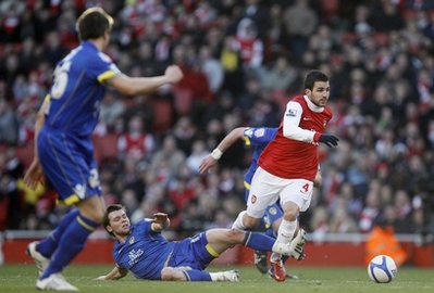 Tiền vệ Cesc Fabregas (áo đỏ, Arsenal) đột phá trước hàng phòng ngự Leeds United.
