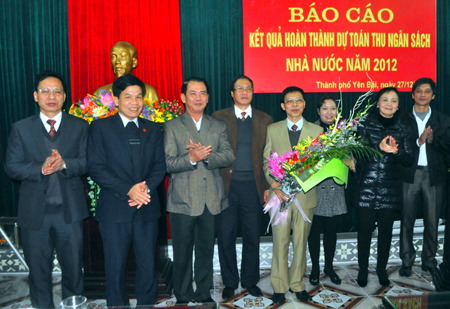 Các đồng chí lãnh đạo thành phố tặng hoa chúc mừng cán bộ, công chức ngành thuế thành phố.
(Ảnh: Thanh Nghị)
