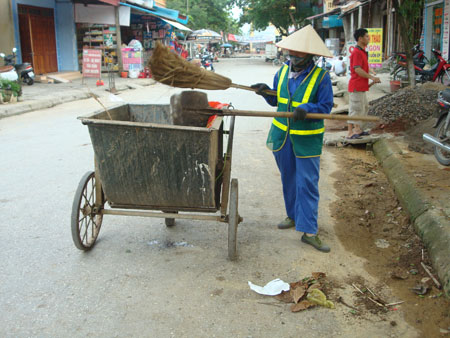 Công nhân Công ty TNHH một thành viên Môi trường & Công trình đô thị Yên Bái quét dọn vệ sinh tại một tuyến phố.