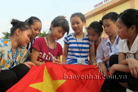 Thanh, thiếu niên Yên Bái ký tên vào lá cờ Tổ quốc thể hiện tình yêu quê hương, biển đảo.
(Ảnh: Hoài Văn)