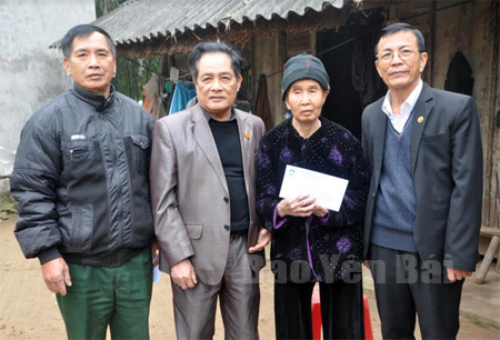 Đồng chí Nguyễn Văn Tỉnh - Chủ tịch Hội Cựu thanh niên xung phong  tỉnh tặng quà tết cho bà Trần Thị Giữa, xã Tuy Lộc (thành phố Yên Bái).