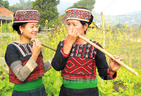 Nghệ nhân Đặng Thị Thanh hướng dẫn các thiếu nữ thổi sáo cúc kẹ.