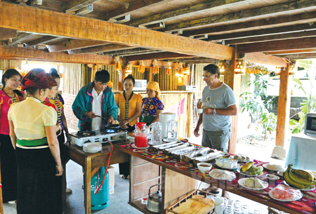 Khách du lịch thưởng thức văn hóa ẩm thực của người Thái Mường Lò. (Ảnh: Thành Trung)
