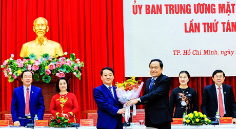 Ông Trần Thanh Mẫn, Chủ tịch Ủy ban Trung ương MTTQ Việt Nam (phải), tặng hoa chúc mừng ông Hầu A Lềnh.