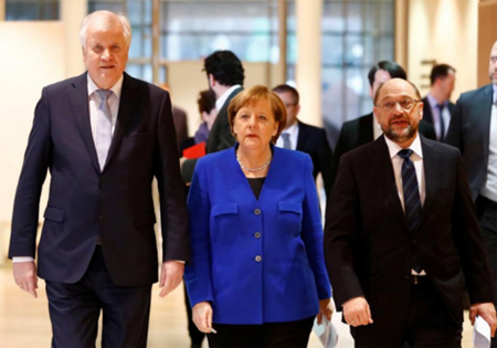 Thủ tướng Merkel và lãnh đạo SPD - Martin Schulz (phải) tiến về phòng họp báo sau khi đạt thỏa thuận thành lập chính phủ liên minh.