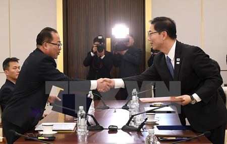 Trưởng đoàn đàm phán Hàn Quốc, Thứ trưởng Bộ Thống nhất Chun Hae-sung (phải) và Trưởng đại diện đàm phán Triều Tiên, Phó Chủ tịch Ủy ban tái thống nhất hòa bình Jon Jong Su (trái) trao đổi văn kiện tại cuộc đàm phán ở làng đình chiến Panmunjom.