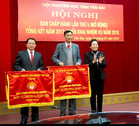 Đồng chí Ngô Thị Chinh - Chủ tịch Hội Khuyến học tỉnh trao cờ thi đua của Trung ương Hội Khuyến học Việt Nam cho 2 tập thể.
