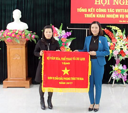 Thừa uỷ quyền của Bộ VH- TT- DL, bà Lê Thị  Thanh Bình – Giám đốc Sở VH-TT-DL trao Cờ thi đua cho Phòng Văn hoá -  Thông tin thị xã Nghĩa Lộ - đơn vị dẫn đầu trong phong trào thi đua năm 2017.