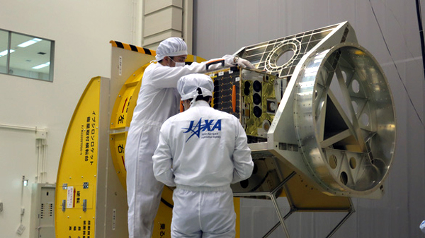 Các kỹ sư Cơ quan Hàng không Vũ trụ Nhật Bản (JAXA) đang lắp đặt thử nghiêm vệ tinh vào bộ gá đặt trong tên lửa.