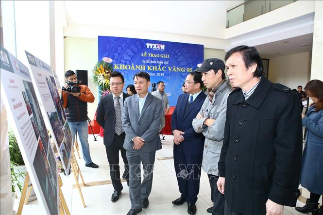 Ủy viên Trung ương Đảng, Tổng giám đốc TTXVN Nguyễn Đức Lợi và các đại biểu tham quan ảnh triển lãm tại Lễ trao giải.