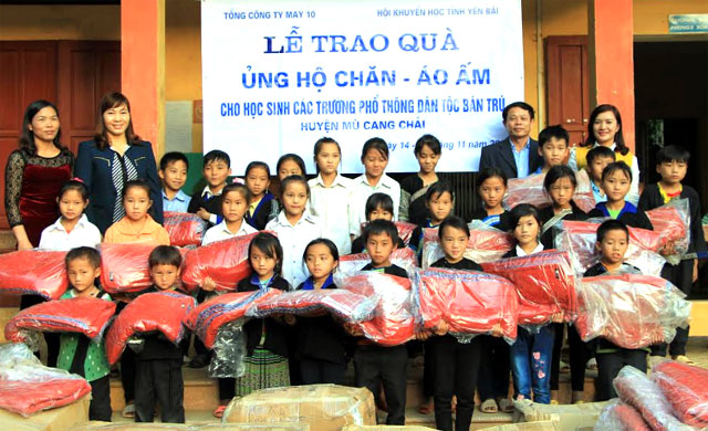 Đại diện lãnh đạo Hội Khuyến học tỉnh và huyện Mù Cang Chải trao chăn, áo ấm cho học sinh Trường PTDT bán trú TH&THCS Khao Mang.