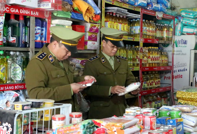 Cán bộ QLTT huyện Yên Bình kiểm tra việc thực hiện ghi nhãn hàng hóa trên bao bì sản phẩm tại các cơ sở kinh doanh.